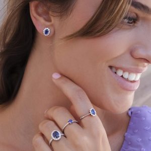 mujer posando con anillos y pendientes de zafiro